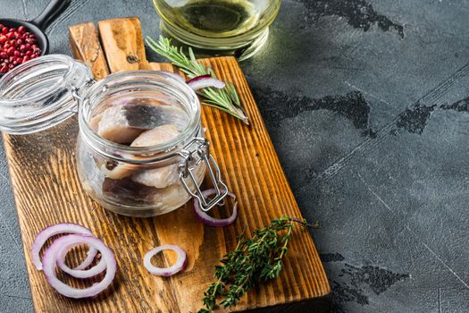 Pickled herring in oil, on gray background with copy space for text