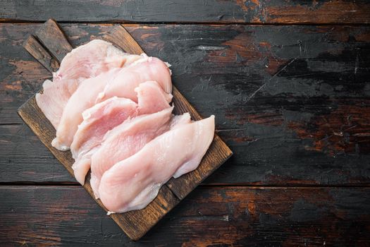Raw organic chicken breasts, on old dark wooden table background, top view flat lay with copy space for text