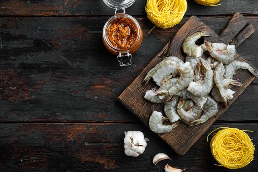 Pasta with shrimp, tomato and pesto sauce ingredients set, on old dark wooden table, top view flat lay, with copy space for text