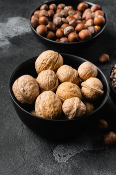 Whole organic walnuts set, on black dark stone table background