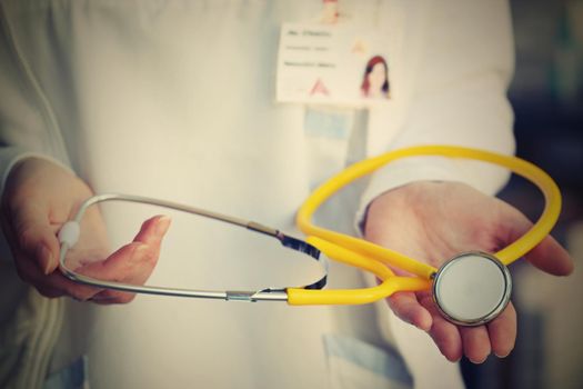 Female doctor holding a stethoscope. Concept for health and medicine. Hospital background.