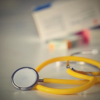 Stethoscope with medication on the table. Concept for health and medicine. Hospital background.