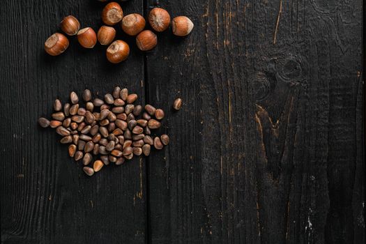 Pine wild organic nut set, on black wooden table background, top view flat lay, with copy space for text