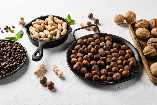 Mix of different nuts, peanut, walnut, pine nuts and hazelnut set, on white stone table background