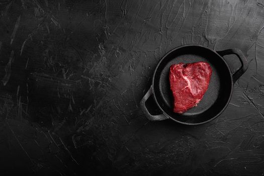 Raw seasoned rump steaks beef meat set, on black dark stone table background, top view flat lay, with copy space for text