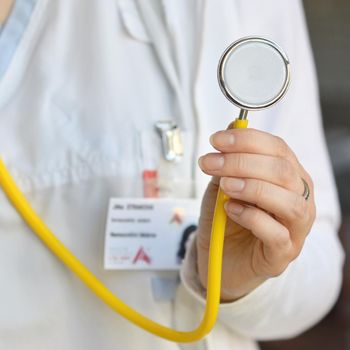 Female doctor holding a stethoscope. Concept for health and medicine. Hospital background.