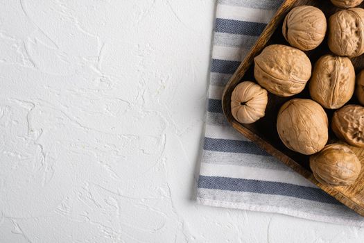 Walnuts with shells set, on white stone table background, top view flat lay, with copy space for text