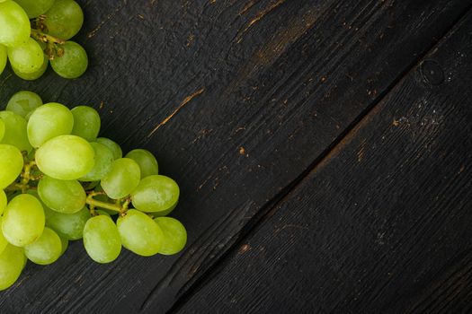 Ripe grape set, green fruits, on black wooden table, top view flat lay, with copy space for text