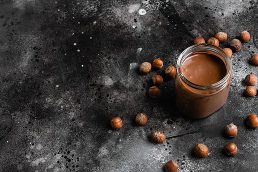 Sweet hazelnut spread set, on black dark stone table background, with copy space for text