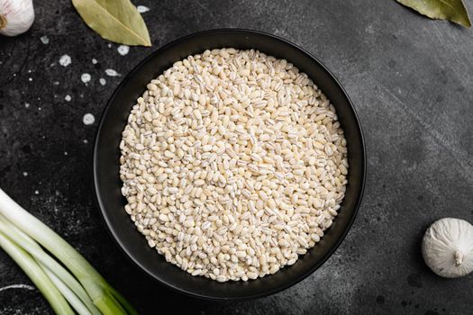 Pearl Barley Heap set, on black dark stone table background, top view flat lay