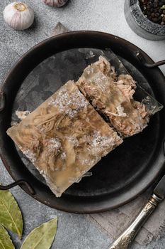 Jellied meat, beef aspic, traditional Russian dish set, on gray stone table background, top view flat lay