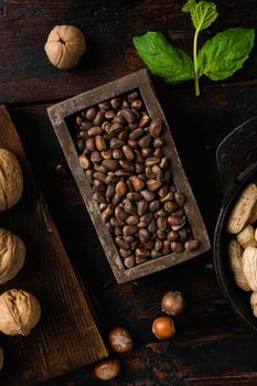 Pine wild organic nut set, on old dark wooden table background, top view flat lay