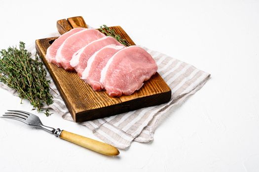 Pork meat. Fresh pork steaks set, on white stone table background, with copy space for text