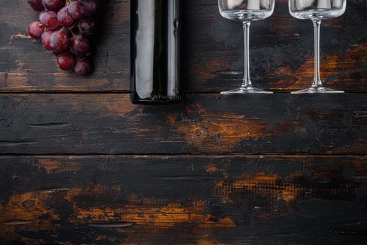 Red wine and grapes set, on old dark wooden table, top view flat lay, with copy space for text