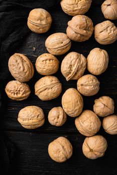 Natural walnut set, on black wooden table background, top view flat lay