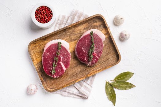 Raw beef steak set, on white stone table background, top view flat lay