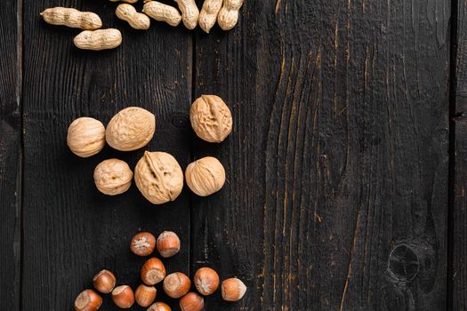 Walnut whole nut set, on black wooden table background, top view flat lay, with copy space for text