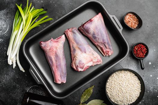 Raw lamb shanks meat set, on black dark stone table background, top view flat lay