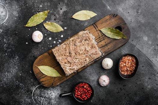 Jellied meat, beef aspic, traditional Russian dish set, on black dark stone table background, top view flat lay