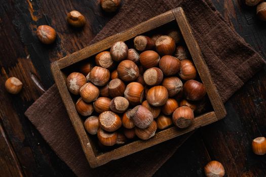 Hazelnuts brown wooden shell set, on old dark wooden table background, top view flat lay