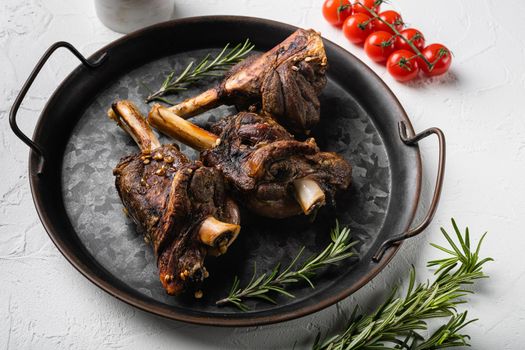 Baked lamb shank with barley and ale set, on white stone table background