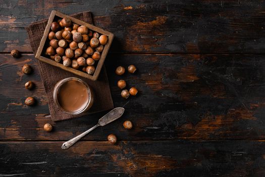 Chocolate spread or nougat cream with hazelnut set, on old dark wooden table background, top view flat lay, with copy space for text