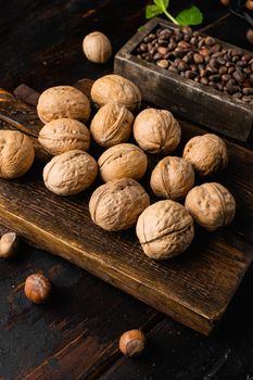 Whole organic walnuts set, on old dark wooden table background