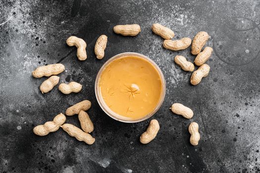 Peanut butter set, on black dark stone table background, top view flat lay, with copy space for text