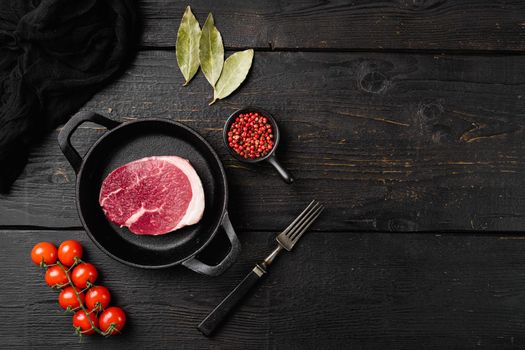 Raw beef steak set, on black wooden table background, top view flat lay, with copy space for text