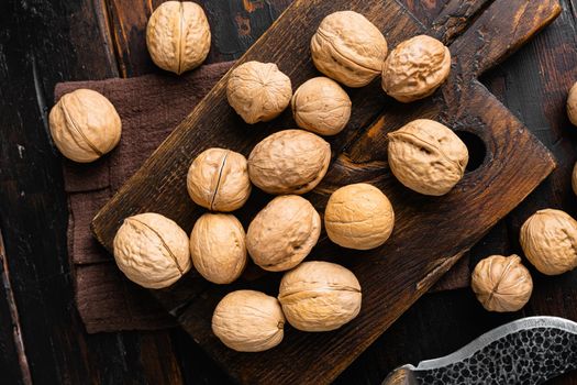 Walnuts with shells set, on old dark wooden table background, top view flat lay