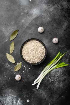 Pearl barley uncooked set, on black dark stone table background, top view flat lay, with copy space for text