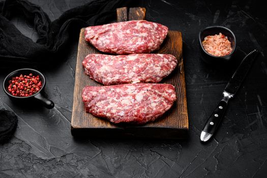 Homemade meat beef cutlets set, on black dark stone table background
