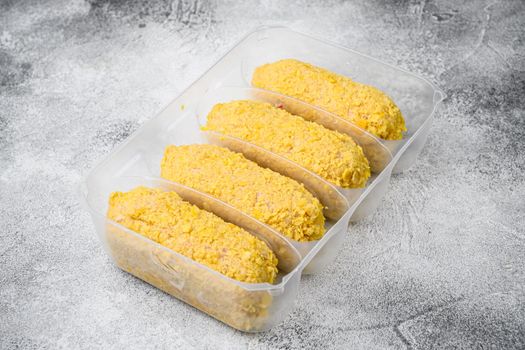 Breaded chicken patty set, in plastic market container, on gray stone table background, with copy space for text