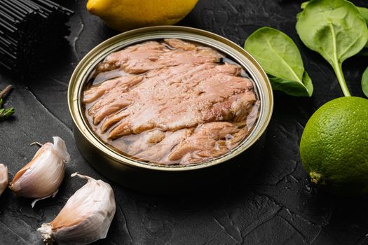 Canned tuna fish set, on black dark stone table background