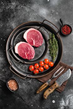 Fresh raw organic beef steak set, on black dark stone table background, top view flat lay