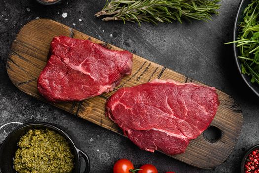 Raw seasoned rump steaks beef meat set, on black dark stone table background, top view flat lay
