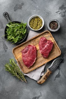 Beef raw rump steak with salt pepper rosemary set, on gray stone table background, top view flat lay