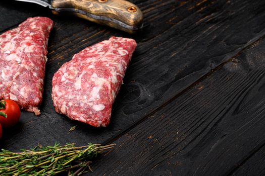 Raw Minced Meat Cutlets set, on black wooden table background, with copy space for text