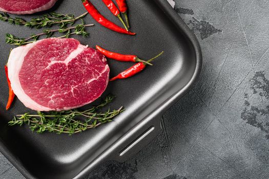 Raw beef steak set, on gray stone table background, top view flat lay, with copy space for text