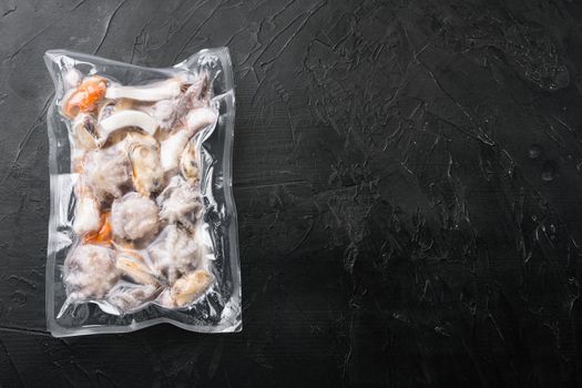 Raw seafood, mussels, squid octopus in vacuum pack set, on black dark stone table background, top view flat lay, with copy space for text