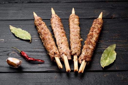 Mutton kebab shish skewers set, on black wooden table background