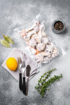 Raw seafood, mussels, squid octopus in vacuum pack set, on gray stone table background, top view flat lay