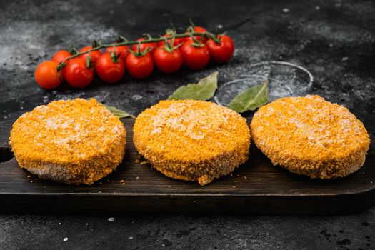 Raw salmon burger patties set, on black dark stone table background