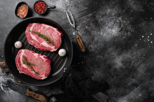 Raw fresh marbled meat Steak Ribeye set, on black dark stone table background, top view flat lay, with copy space for text