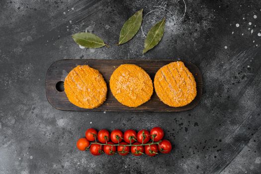 Breaded fish patties set, on black dark stone table background, top view flat lay, with copy space for text