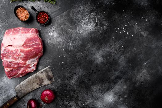 Piece of fresh raw pork from the neck set, with ingredients and herbs , with old butcher cleaver knife, on black dark stone table background, top view flat lay, with copy space for text