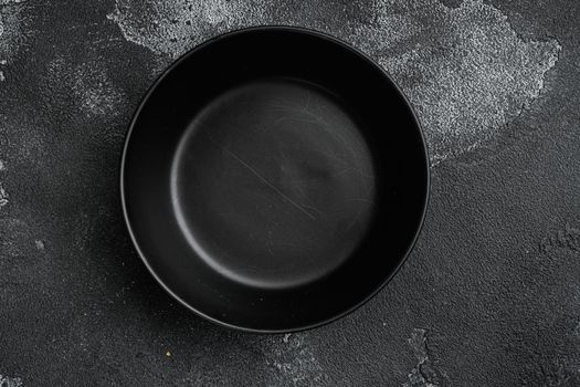 black pottery bowl set, with copy space for text or food, with copy space for text or food, top view flat lay, on black dark stone table background
