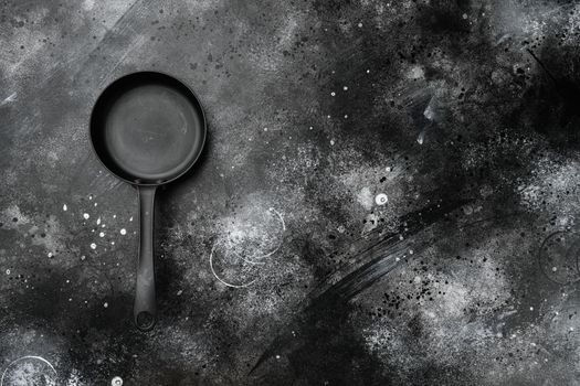 Empty skillet, frying pan set with copy space for text or food with copy space for text or food, top view flat lay, on black dark stone table background