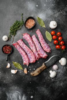 Raw chicken neck set, on black dark stone table background, top view flat lay, with copy space for text