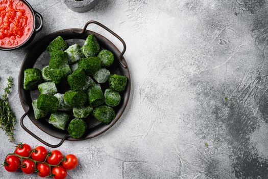 Frozen spinach set, on gray stone table background, top view flat lay, with copy space for text